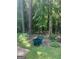 Backyard view with mature trees and a green wheelbarrow at 3705 Sandhill Se Dr, Conyers, GA 30094