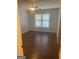 Bedroom featuring hardwood floors, a ceiling fan, and a large window for natural light at 3705 Sandhill Se Dr, Conyers, GA 30094