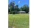 Landscaped front yard with a well-maintained lawn and mature trees at 3705 Sandhill Se Dr, Conyers, GA 30094