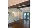 Bright living room with dark hardwood floors, exposed beams, and black framed french doors at 3705 Sandhill Se Dr, Conyers, GA 30094