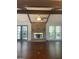 Living room featuring hardwood floors, exposed beams, and a brick fireplace at 3705 Sandhill Se Dr, Conyers, GA 30094