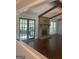 Living room features hardwood floors, brick fireplace, french doors and exposed ceiling beams at 3705 Sandhill Se Dr, Conyers, GA 30094