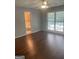 Main bedroom suite, featuring hardwood floors, ceiling fan, and a view to the ensuite bathroom at 3705 Sandhill Se Dr, Conyers, GA 30094