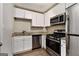 Compact kitchen featuring modern stainless steel appliances, granite countertops, and bright white cabinetry at 2576 Godfrey Nw Dr, Atlanta, GA 30318
