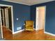 Bedroom with blue walls, a comfortable yellow arm chair and hard wood floors at 0 Hawkins Academy Rd, Social Circle, GA 30025
