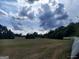 Scenic land featuring cut hay field and scattered trees under a dynamic sky with puffy clouds at 0 Hawkins Academy Rd, Social Circle, GA 30025