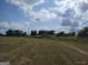Picturesque field with rows of hay bales under a partly cloudy blue sky, perfect for agricultural use at 0 Hawkins Academy Rd, Social Circle, GA 30025