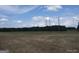 View of land with sparse grass, a tree line in the distance, and blue skies with puffy white clouds above at 0 Hawkins Academy Rd, Social Circle, GA 30025