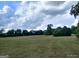 Expansive grassy land with scattered trees and a dramatic sky, ideal for a future development at 0 Hawkins Academy Rd, Social Circle, GA 30025