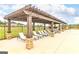 Poolside pergola featuring stone columns, wood beams, and ample lounge seating for relaxing by the pool at 1613 Fuma Leaf Way # 273, Mcdonough, GA 30253