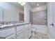 Bathroom featuring double sink vanity with granite countertop, a tiled bathtub and shower, and modern fixtures at 6116 Ripple Way # 47, South Fulton, GA 30349