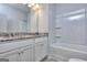 Bright bathroom featuring a white vanity with granite countertop and a shower-tub combo with modern fixtures at 6116 Ripple Way # 47, South Fulton, GA 30349