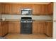 Functional kitchen equipped with classic oak cabinets and black appliances at 207 Millwheel Dr, Villa Rica, GA 30180