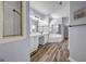 Bathroom featuring double sink vanity, soaking tub, separate shower, and wood-look tile floor at 269 Legends Trce, Mcdonough, GA 30253