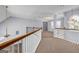 Upstairs hallway featuring neutral carpet, wood railings, and chandeliers at 269 Legends Trce, Mcdonough, GA 30253
