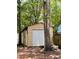 Backyard features a metal storage shed with white roll-up door and plenty of shade at 215 Highland Dr, Locust Grove, GA 30248