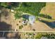Aerial view of an estate with a circular driveway, swimming pool, pond, and surrounding trees at 1875 Highway 142 E, Covington, GA 30014