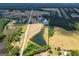 Aerial view showcasing a large pond with surrounding trees and a distant home at 1875 Highway 142 E, Covington, GA 30014