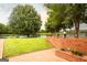 A peaceful backyard with a serene lake view, lush green lawn, and a charming brick patio at 1875 Highway 142 E, Covington, GA 30014