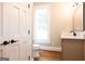 Bathroom with a white toilet, grey vanity, and sleek black fixtures and door hardware at 1875 Highway 142 E, Covington, GA 30014