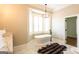 Bright bathroom features a freestanding tub by a large bay window with shutters, and a modern chandelier at 1875 Highway 142 E, Covington, GA 30014