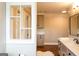 Bathroom view showcasing white marble counters, cabinets, a stylish window, and wood flooring at 1875 Highway 142 E, Covington, GA 30014