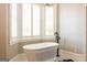 Bright bathroom features a freestanding tub and large bay window with plantation shutters at 1875 Highway 142 E, Covington, GA 30014