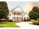 Stately two-story white home with black shutters and a brick walkway leading to the front door at 1875 Highway 142 E, Covington, GA 30014