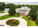 Beautiful white estate with a grand entrance, circular driveway, and lush landscaping at 1875 Highway 142 E, Covington, GA 30014