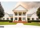 A grand two-story white home featuring stately columns, black shutters, and lush landscaping at 1875 Highway 142 E, Covington, GA 30014