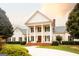 Elegant white home featuring stately columns and a well-manicured lawn with mature trees at 1875 Highway 142 E, Covington, GA 30014