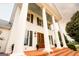 An elegant home with a grand entrance featuring a double door, large columns, and beautiful brick steps at 1875 Highway 142 E, Covington, GA 30014