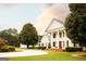 Grand white home featuring stately columns and lush landscaping, set back from the road at 1875 Highway 142 E, Covington, GA 30014