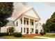 Elegant white home with black shutters, brick steps, and meticulously maintained landscaping at 1875 Highway 142 E, Covington, GA 30014