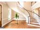 Stunning foyer with a curved staircase, elegant table, and beautiful hardwood floors at 1875 Highway 142 E, Covington, GA 30014