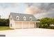 Three-car garage with white doors and dormer windows and gray roof on landscaped property at 1875 Highway 142 E, Covington, GA 30014