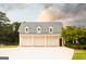 Detached three-car garage with white doors and dormer windows, next to a lush green yard at 1875 Highway 142 E, Covington, GA 30014