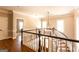 Hallway features hardwood floors, chandelier, and a view to the lower level at 1875 Highway 142 E, Covington, GA 30014