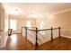Upstairs hallway with hardwood floors, modern chandelier, and plenty of natural light at 1875 Highway 142 E, Covington, GA 30014