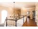 Beautiful upstairs hallway with a modern chandelier and hardwood floors at 1875 Highway 142 E, Covington, GA 30014