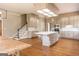 Open kitchen with an island, light fixtures, and hardwood floors leading to the stairs at 1875 Highway 142 E, Covington, GA 30014