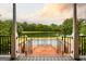 Black wrought iron fence overlooks the in-ground pool, with a serene lake and wooded view beyond at 1875 Highway 142 E, Covington, GA 30014