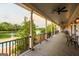 Relaxing porch with a ceiling fan, chairs and tables overlooking a serene lake view at 1875 Highway 142 E, Covington, GA 30014