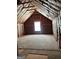 Bright unfinished attic space with exposed beams and insulation featuring a window for natural light at 362 Arbor Ridge Pkwy, Mcdonough, GA 30253