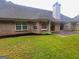 Well-kept backyard featuring lush green grass, mature landscaping, and a brick facade of the home at 362 Arbor Ridge Pkwy, Mcdonough, GA 30253