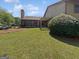 Home's backyard features a well-maintained lawn and mature trees at 1084 Village Rd, Stone Mountain, GA 30088