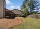 A spacious backyard featuring a covered patio area, lawn, and wooded perimeter in a quiet neighborhood at 1084 Village Rd, Stone Mountain, GA 30088
