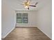 Empty bedroom with ceiling fan and windows overlooking street at 1084 Village Rd, Stone Mountain, GA 30088