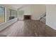 Bright living room with wood floors, brick fireplace, large windows offering backyard view, and staircase at 1084 Village Rd, Stone Mountain, GA 30088