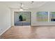 Open-concept living area featuring wood floors, a ceiling fan, and sliding glass doors leading to the patio at 1084 Village Rd, Stone Mountain, GA 30088